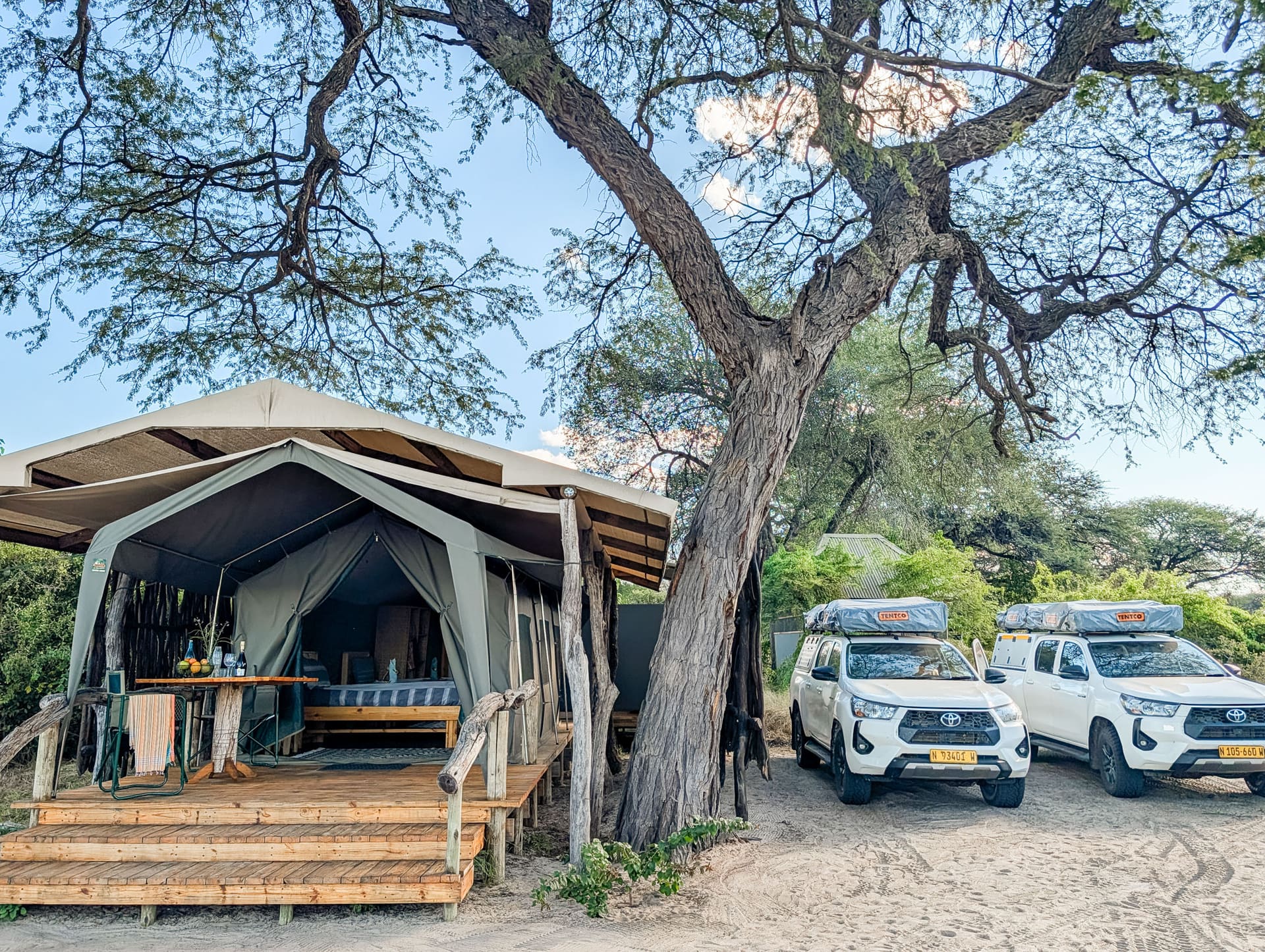 Vehicles parked beside a safari tent