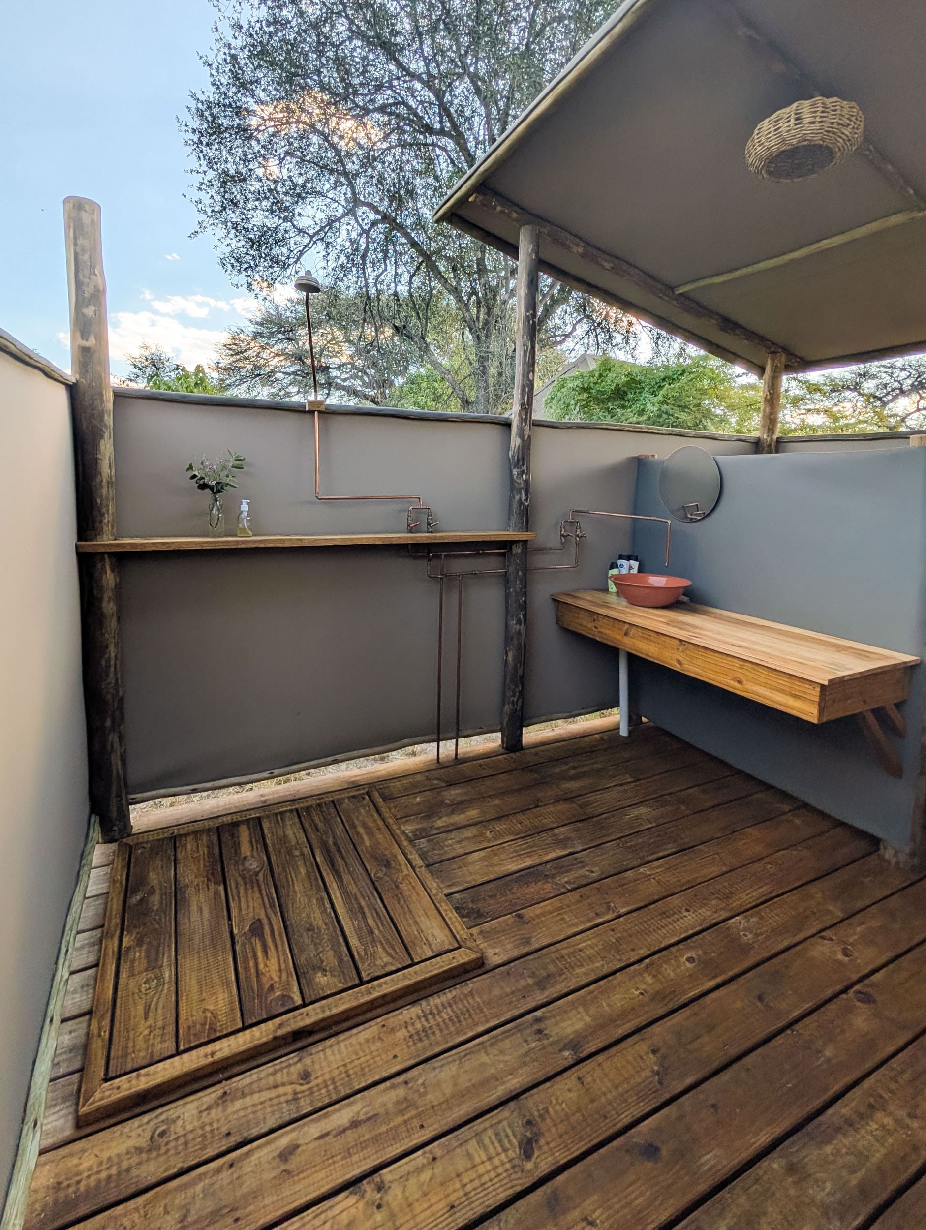 Outdoor shower behind a safari tent